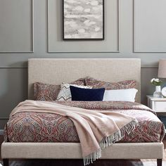 a bedroom with a bed, nightstands and paintings on the wall above it's headboard