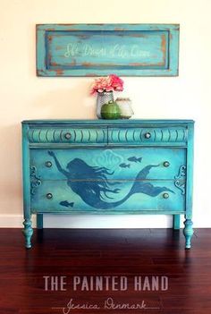 an old dresser painted with mermaid silhouettes