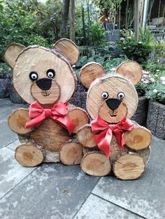 two teddy bears made out of wood with red bows on their heads and eyes are sitting next to each other