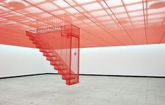 an empty room with red stairs in the center