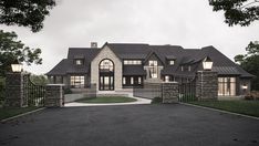 a large house with stone walls and black iron fenced in driveway leading to it's front entrance