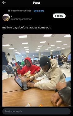 two people sitting at a table with laptops in front of them and one person typing on the keyboard