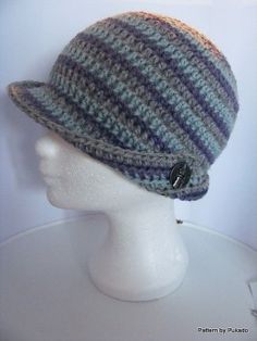 a white mannequin head wearing a knitted hat with buttons on the brim