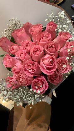 a bouquet of pink roses sitting on top of a table