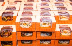 several boxes filled with donuts covered in frosting and sprinkles are stacked on top of each other