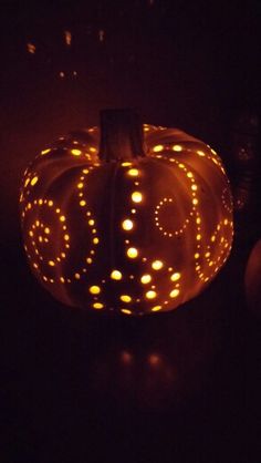 a lighted pumpkin sitting on top of a table