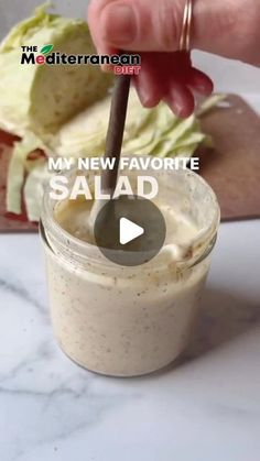 a person is holding a spoon over a salad in a glass jar with the words my new favorite salad on it