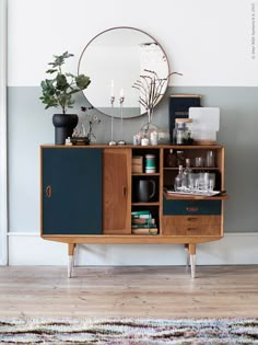 a wooden cabinet sitting on top of a hard wood floor next to a white wall