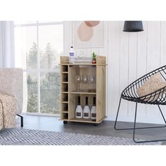 a room with a chair, table and bottles on the shelf next to a window