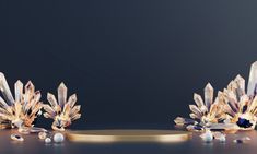 two gold and crystal pieces on a black surface