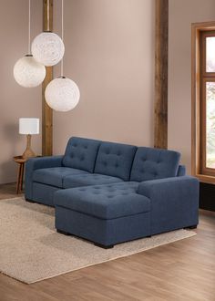 a blue sectional sofa sitting on top of a wooden floor next to a lamp shade