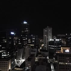 cityscape at night with skyscrapers lit up in the distance and lights on