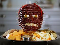 a plate topped with lots of food and a face made out of meats on top of it