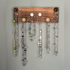 a wooden rack with lots of necklaces hanging from it's sides on a wall