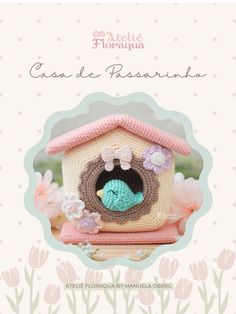 a crocheted birdhouse with flowers on the front and bottom, in pink