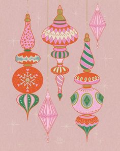 christmas ornaments hanging from strings on a pink background