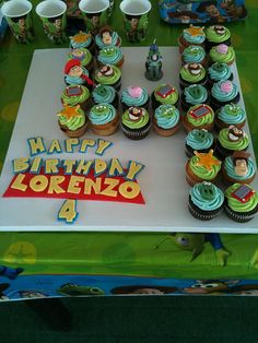 a birthday cake and cupcakes are arranged on a table