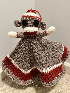 a crocheted sock monkey is sitting on the floor