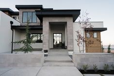 a modern house with stairs leading to the front door