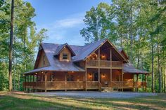 a large log home in the woods surrounded by trees