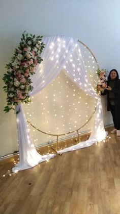 a woman standing in front of a wedding arch