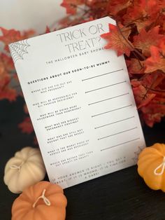 a trick or treat card sitting on top of a table next to fake pumpkins