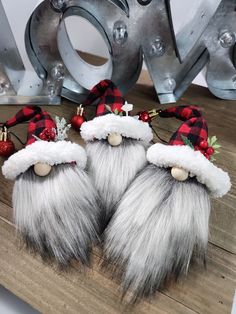 two furry christmas gnomes are sitting on a wooden table