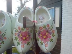 several pairs of painted shoes hanging on a rack