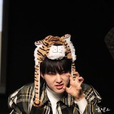 a young man wearing a tiger hat on top of his head