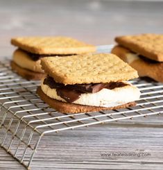 three cookies and ice cream sandwiches on a cooling rack, with one cookie sandwich cut in half