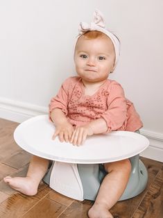 a baby sitting in a potty with a white plate on it's seat