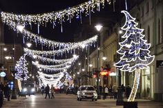 a city street is decorated with christmas lights and garlands, as well as decorations