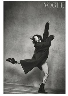 black and white photograph of a woman in an overstuffed coat dancing with her legs spread out