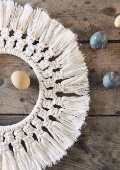 a white crocheted doily sitting on top of a wooden table next to eggs