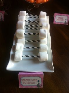 marshmallows are arranged on a plate with black and white paper straws