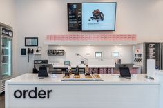 the inside of a store with an order counter and phone on display in front of it