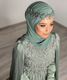 a woman wearing a green hijab with silver sequins on the head