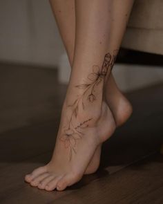 a woman's foot with a flower tattoo on her left side and the bottom part of her leg