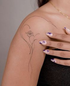 a woman's arm with tattoos on it and flowers painted on the back of her arm