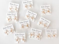 six pairs of hair clips in white and gold with matching labels on them for sale