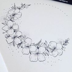 a drawing of some flowers on a sheet of paper with marker pens next to it