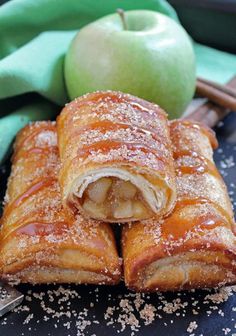 apple turnovers with powdered sugar and cinnamon on a plate next to an apple