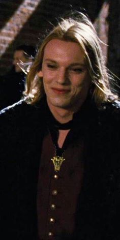 a man with long blonde hair wearing a black jacket