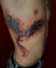 a man with a tattoo on his stomach has an eagle and flames behind him,