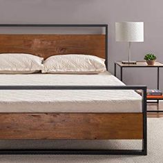 a bed that is made up with wooden headboard and foot board on the side