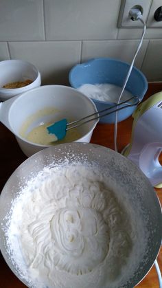 there are many bowls on the table with food in them, including cake batter and other ingredients