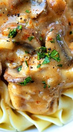 chicken and mushroom gravy over pasta on a white plate