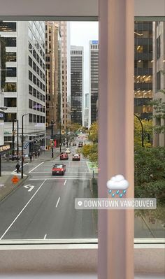 an image of a city street taken through a window