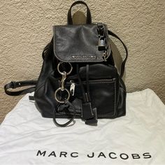 Marc Jacobs The Bold Grind Leather Backpack - Color: Black - Material: Grained Leather Exterior - Condition: Used - Fair Condition - Dimensionsl 10.5"W X 5.5"D X 12"H; 4" Handle Drop - One Exterior Zip Pocket, Three Interior Slip Pockets, And One Interior Zip Pocket - Dust Bag Included Feel Free To Comment/Message With Any Questions. Thanks! Leather Travel Backpack With Silver-tone Hardware, Luxury Leather Backpack With Silver-tone Hardware, Leather Backpack With Silver-tone Hardware For Travel, Designer Leather Backpack With Branded Hardware, Everyday Leather Backpack With Branded Hardware, Leather Backpack With Branded Hardware For Daily Use, Luxury Leather Backpack With Branded Hardware For Everyday, Designer Leather Backpack With Adjustable Strap For Errands, Marc Jacob Backpack