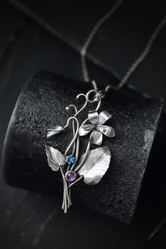 ITEM DESCRIPTION: The size H 5 cm x W 3 cm (2 x 1 1/3 inch). Weight - 3 g. You can buy it with a silver chain or without it. This spring flower is so delicate. So I was inspired by nature and made a wild violet flower of sterling silver, amethyst, and blue zircon. This is a very detailed handmade necklace. This floral jewelry will be a great addition to your jewelry collection or gift for someone whose you love. This handmade necklace will come to you in a gift box - ready for gifting. The parce Unique Flower Pendant Necklaces With Charm, Silver Nature-inspired Necklace With Flower Charm, Silver Necklace With Nature-inspired Flower Charm, Nature-inspired Flower Charm Pendant Necklace, Nature-inspired Silver Flower Necklace With Charm, Nature-inspired Flower Shaped Sterling Silver Jewelry, Nature-inspired Sterling Silver Flower Jewelry, Sterling Silver Flower Pendant Jewelry, Silver Birth Flower Pendant Jewelry